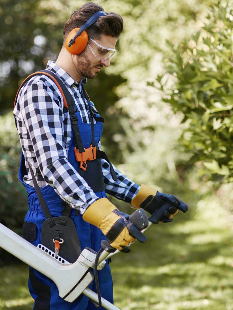 Man with weedwacker cutting the grass